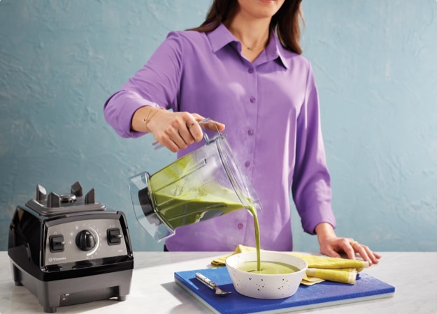 Woman pouring mizture cout of Propel Series Blender