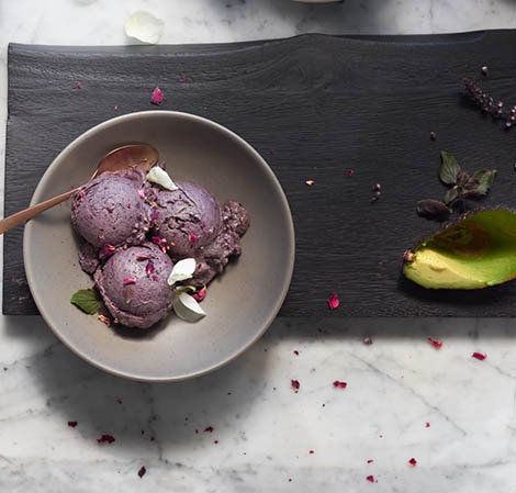 Crème glacée sans produits laitiers aux bleuets et à l'avocat blueberry avocado nice cream in a gray bowl with an avocado peel off to the side