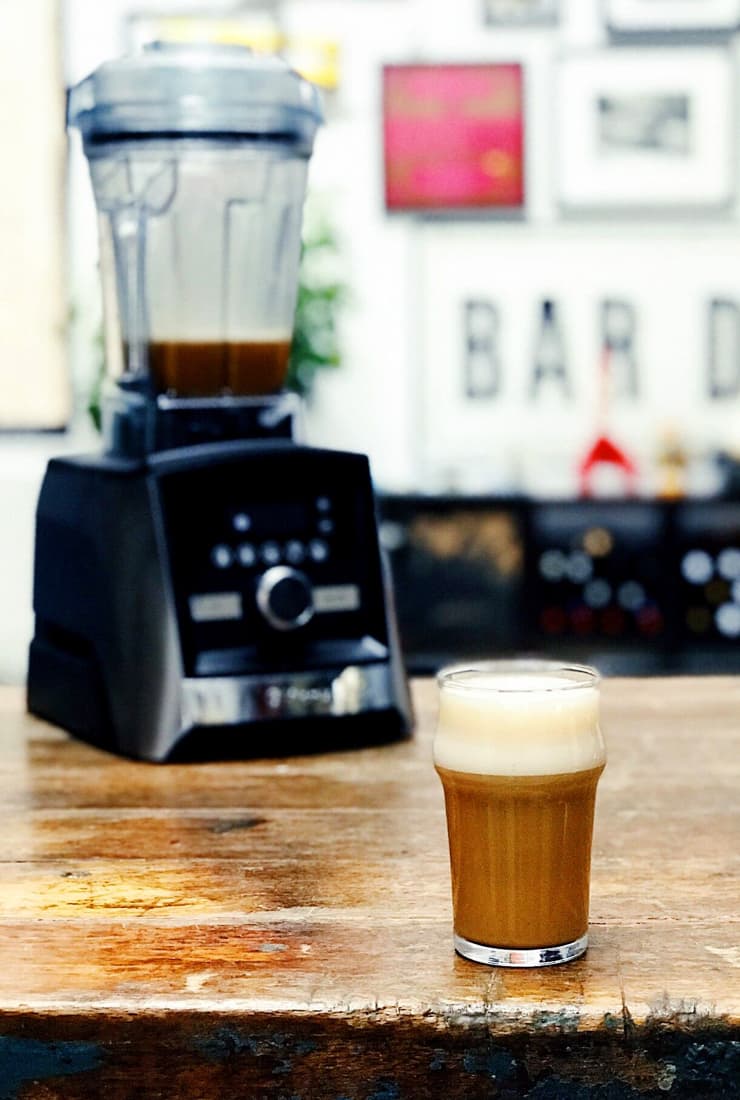 Coffee drink on wood table with Vitamix blender