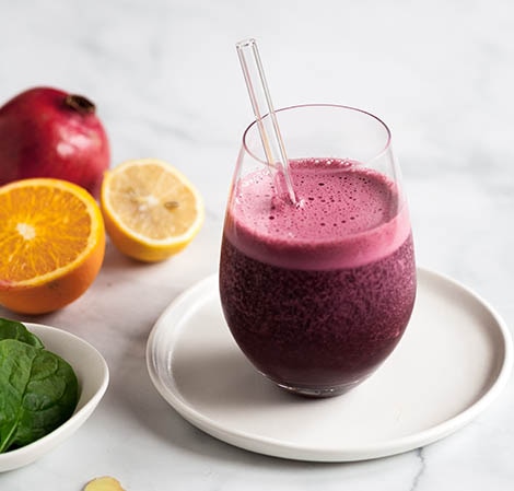 Pomegranate Beet Smoothie Purple smoothie in a glass with a clear straw in it